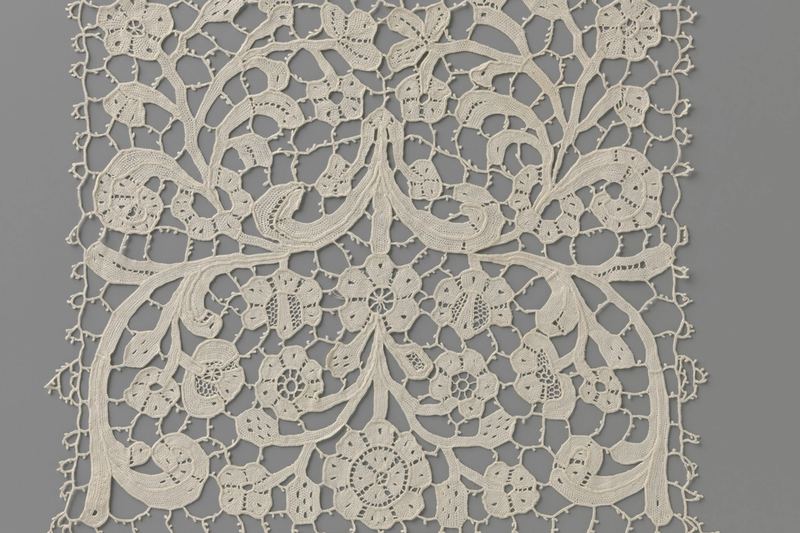 Panel de encaje de crochet color crudo con un motivo floral que se repite de forma regular